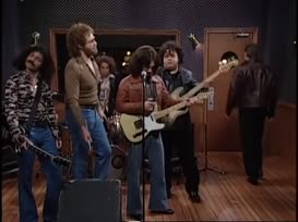 Clip of quote: [ the group starts the song again, as Gene bangs more wildly onto the cowbell, gyrating his exposed belly. In the booth, Walken is smiling to keep from laughing. Before the session is interrupted, Gene misses a beat on his cowbell.]